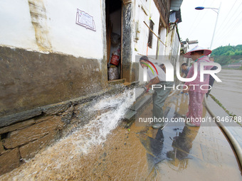 Villagers are cleaning up silt at Changjing Village in Qiukou, Wuyuan county, Shangrao city, East China's Jiangxi province, on June 20, 2024...