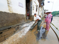 Villagers are cleaning up silt at Changjing Village in Qiukou, Wuyuan county, Shangrao city, East China's Jiangxi province, on June 20, 2024...