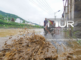 Villagers are cleaning up silt at Changjing Village in Qiukou, Wuyuan county, Shangrao city, East China's Jiangxi province, on June 20, 2024...