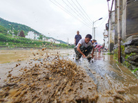 Villagers are cleaning up silt at Changjing Village in Qiukou, Wuyuan county, Shangrao city, East China's Jiangxi province, on June 20, 2024...