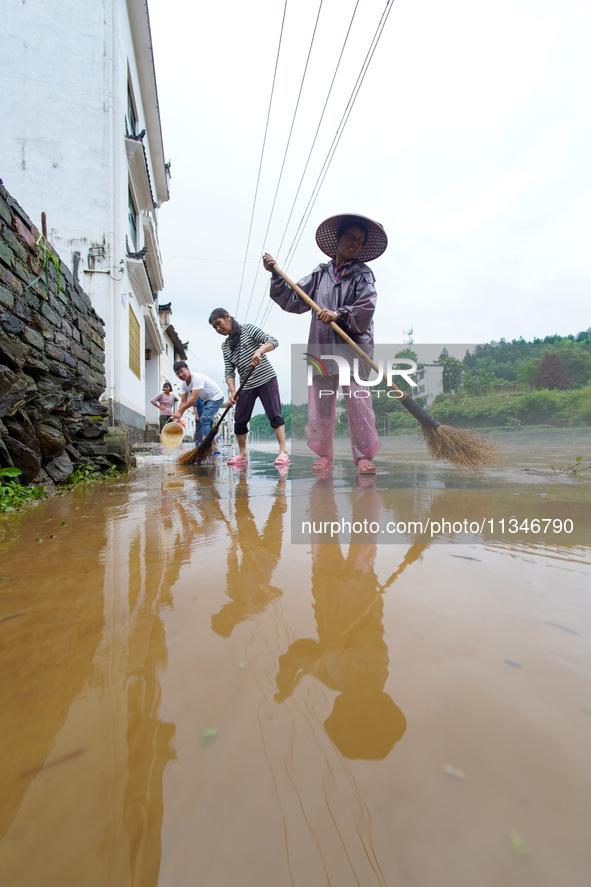 Villagers are cleaning up silt at Changjing Village in Qiukou, Wuyuan county, Shangrao city, East China's Jiangxi province, on June 20, 2024...