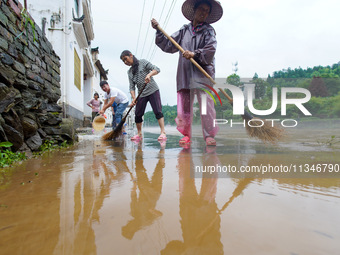 Villagers are cleaning up silt at Changjing Village in Qiukou, Wuyuan county, Shangrao city, East China's Jiangxi province, on June 20, 2024...