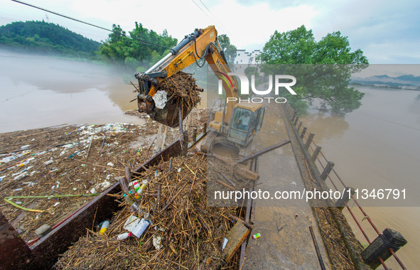 Villagers are cleaning up silt at Changjing Village in Qiukou, Wuyuan county, Shangrao city, East China's Jiangxi province, on June 20, 2024...