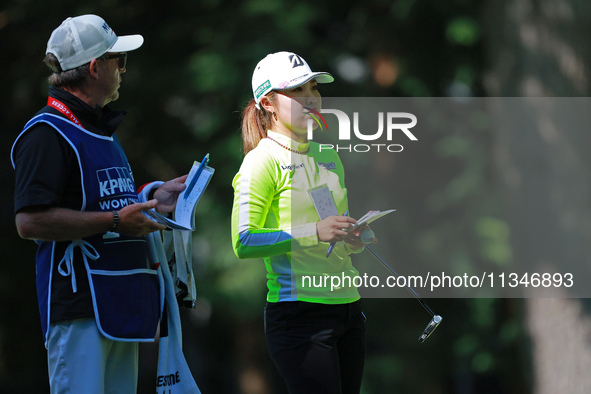 Ayaka Furue of Japan interacts with her caddy on the 16th hole during Day One of the KPMG Women's PGA Championship at Sahalee Country Club i...