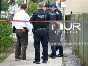 Police officers are investigating the crime scene. Shell casings are being recovered at the crime scene. A 19-year-old male victim is being...