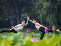 Yoga lovers are practicing yoga on the lotus pond trestle at Tiande Lake Park in Taizhou, China, on June 21, 2024. (