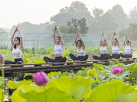 Yoga lovers are practicing yoga on the lotus pond trestle at Tiande Lake Park in Taizhou, China, on June 21, 2024. (