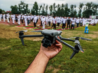 A man is holding his drone as he is waiting for the start of the 10th Yoga Day celebrations in Baramulla, Jammu and Kashmir, India, on June...