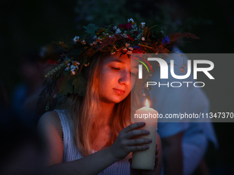 A girl celebrates the summer solstice during the 'Kupala Night' by the Krakus Mound in Krakow, Poland on June 20th, 2024. The Kupała Night i...