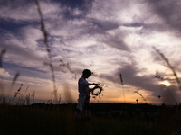 A girl is picking wild plants while celebrating the summer solstice during the 'Kupala Night' by the Krakus Mound in Krakow, Poland on June...