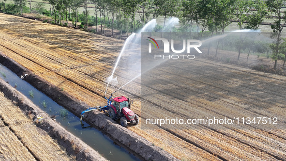 Villagers are carrying out irrigation work in Guangming village, Lianyungang city, East China's Jiangsu province, on June 21, 2024. 