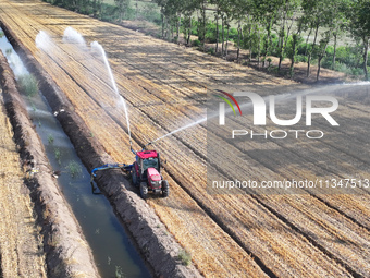 Villagers are carrying out irrigation work in Guangming village, Lianyungang city, East China's Jiangsu province, on June 21, 2024. (