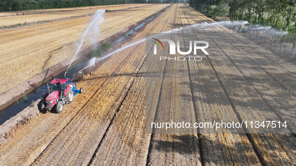 Villagers are carrying out irrigation work in Guangming village, Lianyungang city, East China's Jiangsu province, on June 21, 2024. 