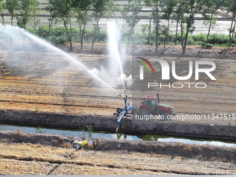 Villagers are carrying out irrigation work in Guangming village, Lianyungang city, East China's Jiangsu province, on June 21, 2024. (