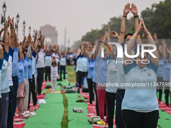 People are performing Yoga on the occasion of International Yoga Day, on the lawns of Kartavya Path, in front of India Gate, in New Delhi, I...