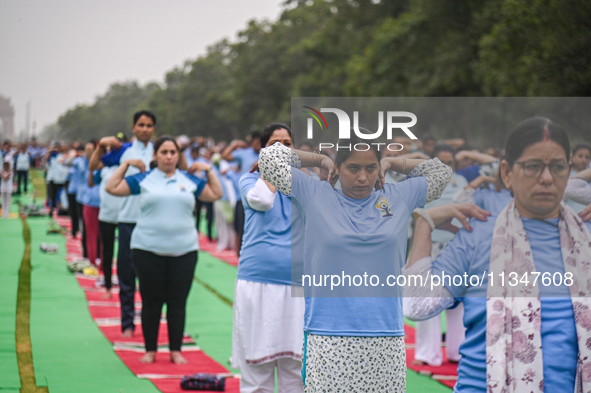 People are performing Yoga on the occasion of International Yoga Day, on the lawns of Kartavya Path, in front of India Gate, in New Delhi, I...