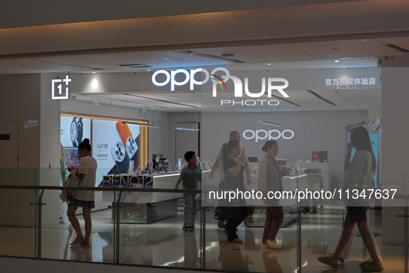 Customers are walking past an OPPO authorized experience store in Shanghai, China, on June 21, 2024. In the first quarter of 2024, Apple is...