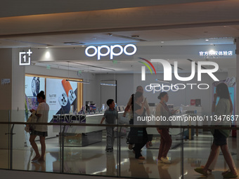 Customers are walking past an OPPO authorized experience store in Shanghai, China, on June 21, 2024. In the first quarter of 2024, Apple is...