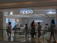 Customers are walking past an OPPO authorized experience store in Shanghai, China, on June 21, 2024. In the first quarter of 2024, Apple is...