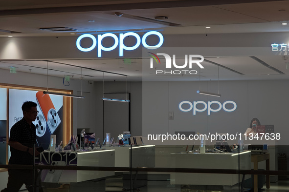 Customers are walking past an OPPO authorized experience store in Shanghai, China, on June 21, 2024. In the first quarter of 2024, Apple is...