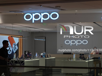 Customers are walking past an OPPO authorized experience store in Shanghai, China, on June 21, 2024. In the first quarter of 2024, Apple is...