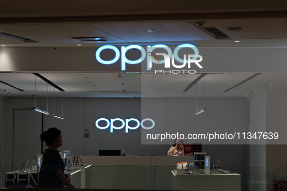 Customers are walking past an OPPO authorized experience store in Shanghai, China, on June 21, 2024. In the first quarter of 2024, Apple is...