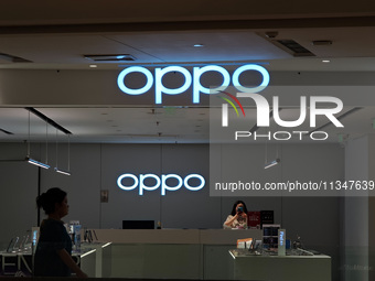 Customers are walking past an OPPO authorized experience store in Shanghai, China, on June 21, 2024. In the first quarter of 2024, Apple is...