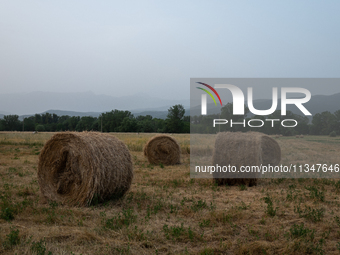 Hay bales are seen in a hazy landscape in L’Aquila, Italy, on June 20th, 2024. High atmospheric pressure from Africa (african anticyclone) i...