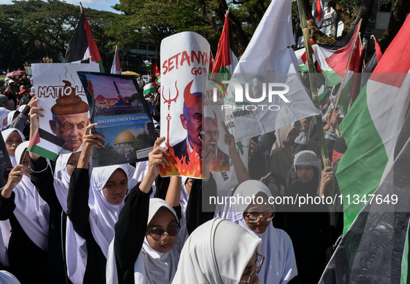 A pro-Palestinian activist is taking part in a protest against Israeli attacks on Gaza and Rafah (refugee camp) with a poster of Benjamin Ne...