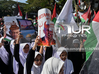 A pro-Palestinian activist is taking part in a protest against Israeli attacks on Gaza and Rafah (refugee camp) with a poster of Benjamin Ne...