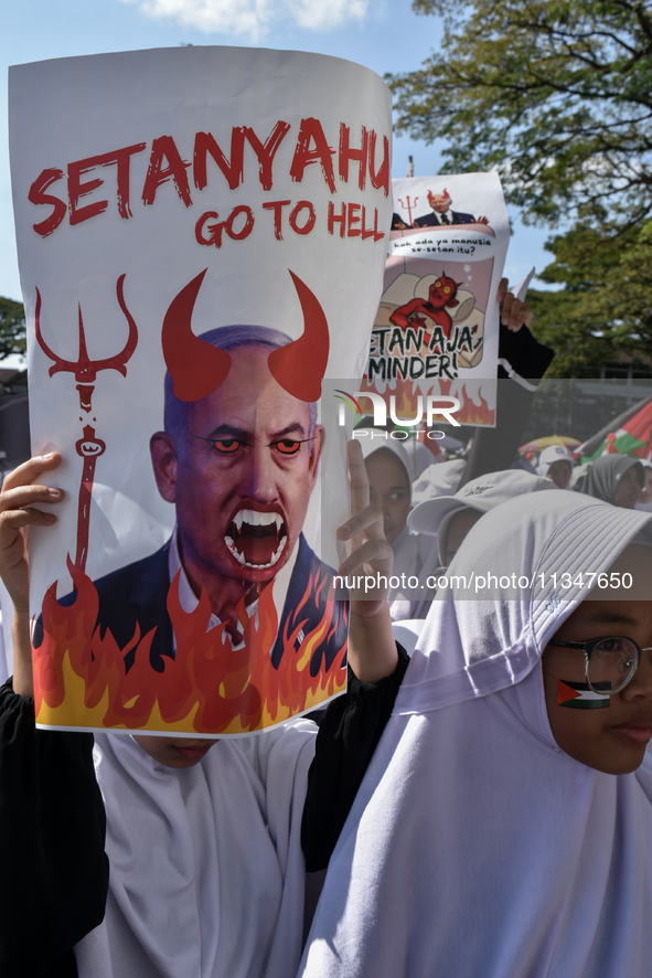 A pro-Palestinian activist is taking part in a protest against Israeli attacks on Gaza and Rafah (refugee camp) with a poster of Benjamin Ne...