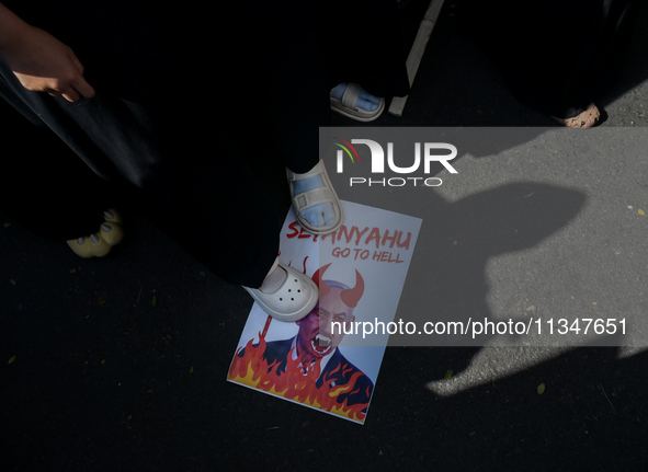 A pro-Palestinian activist is taking part in a protest against Israeli attacks on Gaza and Rafah (refugee camp) with a poster of Benjamin Ne...