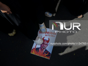 A pro-Palestinian activist is taking part in a protest against Israeli attacks on Gaza and Rafah (refugee camp) with a poster of Benjamin Ne...