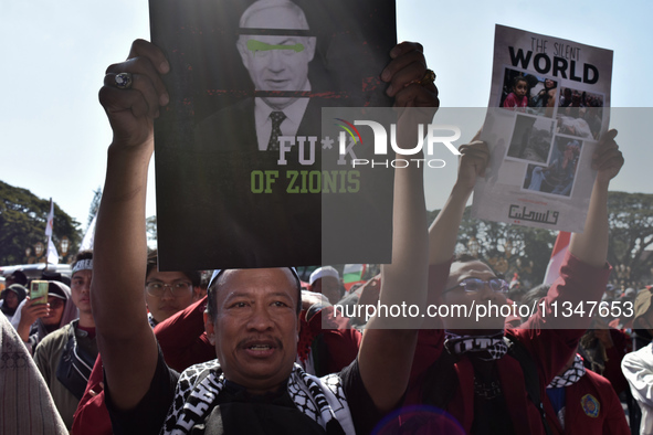 A pro-Palestinian activist is taking part in a protest against Israeli attacks on Gaza and Rafah (refugee camp) with a poster of Benjamin Ne...