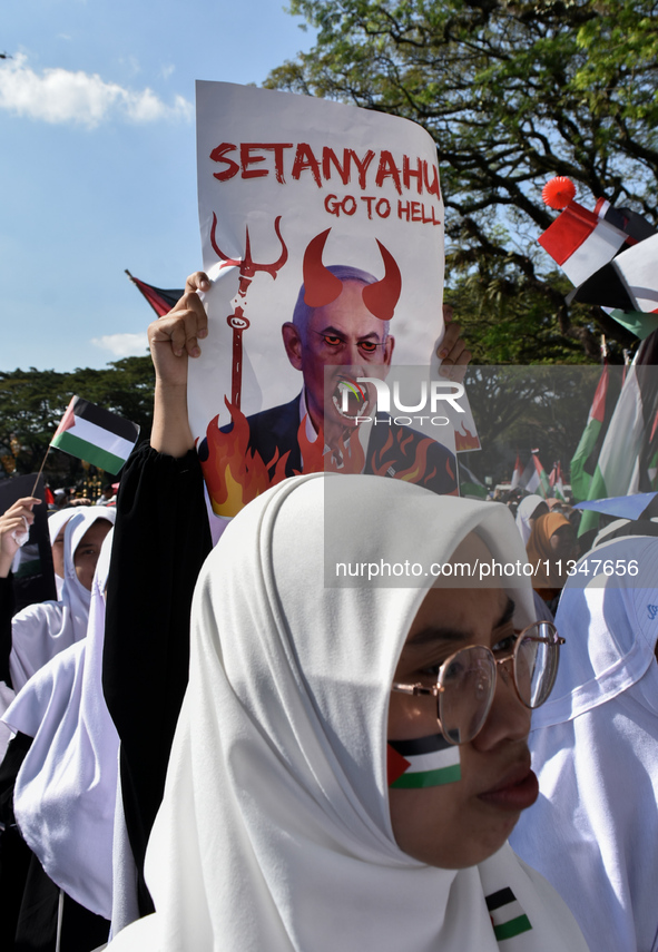 A pro-Palestinian activist is taking part in a protest against Israeli attacks on Gaza and Rafah (refugee camp) with a poster of Benjamin Ne...