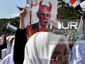 A pro-Palestinian activist is taking part in a protest against Israeli attacks on Gaza and Rafah (refugee camp) with a poster of Benjamin Ne...