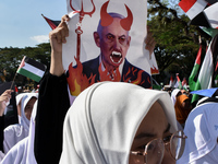 A pro-Palestinian activist is taking part in a protest against Israeli attacks on Gaza and Rafah (refugee camp) with a poster of Benjamin Ne...