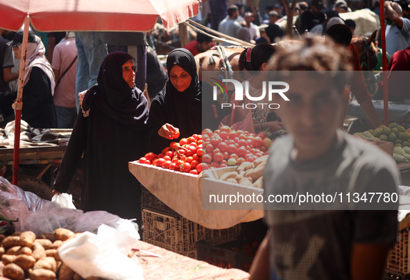 A Palestinian is displaying his wares in a market in Deir al-Balah in the central Gaza Strip, on June 21, 2024, as the conflict is continuin...