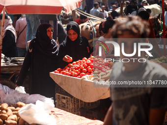 A Palestinian is displaying his wares in a market in Deir al-Balah in the central Gaza Strip, on June 21, 2024, as the conflict is continuin...