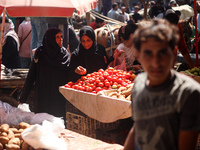 A Palestinian is displaying his wares in a market in Deir al-Balah in the central Gaza Strip, on June 21, 2024, as the conflict is continuin...