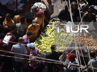 A Palestinian is displaying his wares in a market in Deir al-Balah in the central Gaza Strip, on June 21, 2024, as the conflict is continuin...