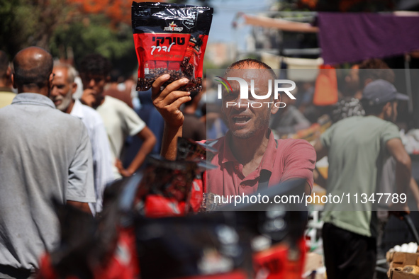 A Palestinian is displaying his wares in a market in Deir al-Balah in the central Gaza Strip, on June 21, 2024, as the conflict is continuin...