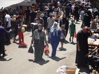 People are walking in a market in Deir al-Balah in the central Gaza Strip, on June 21, 2024, as the conflict in the Palestinian territory be...