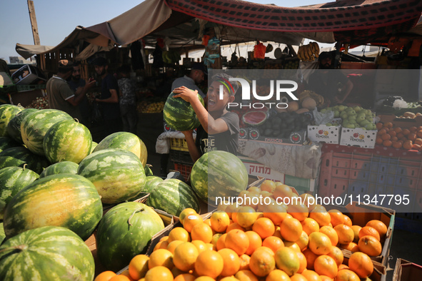 A Palestinian is displaying his wares in a market in Deir al-Balah in the central Gaza Strip, on June 21, 2024, as the conflict is continuin...