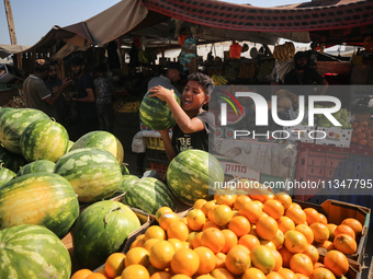 A Palestinian is displaying his wares in a market in Deir al-Balah in the central Gaza Strip, on June 21, 2024, as the conflict is continuin...