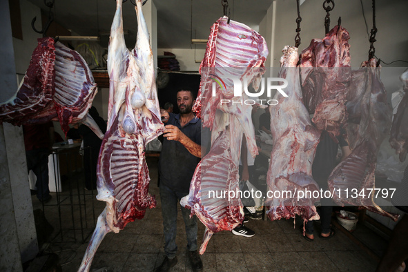 A Palestinian is displaying his wares in a market in Deir al-Balah in the central Gaza Strip, on June 21, 2024, as the conflict is continuin...