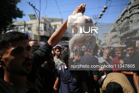 A Palestinian is displaying his wares in a market in Deir al-Balah in the central Gaza Strip, on June 21, 2024, as the conflict is continuin...