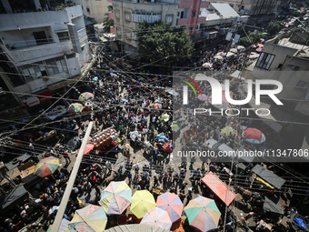 People are walking in a market in Deir al-Balah in the central Gaza Strip, on June 21, 2024, as the conflict in the Palestinian territory be...