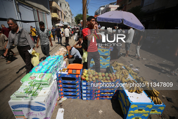 A Palestinian is displaying his wares in a market in Deir al-Balah in the central Gaza Strip, on June 21, 2024, as the conflict is continuin...