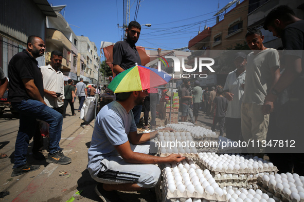 A Palestinian is displaying his wares in a market in Deir al-Balah in the central Gaza Strip, on June 21, 2024, as the conflict is continuin...